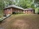 Expansive brick home with a well-manicured lawn and mature trees, offering classic charm and a serene setting at 115 Stable Creek Rd, Fayetteville, GA 30215