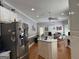Bright kitchen with stainless steel refrigerator, island, hardwood floors and white cabinets at 115 Stable Creek Rd, Fayetteville, GA 30215