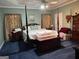 Spacious main bedroom features a four-poster bed, an area rug, and complementary bedside tables at 115 Stable Creek Rd, Fayetteville, GA 30215