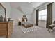 Cozy bedroom with natural light, neutral tones, carpet, and a wooden accent dresser at 135 Wet Wood Dr # 12, Fairburn, GA 30213