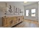 Elegant entryway with light wood floors, modern sideboard with leaf art, and natural light at 135 Wet Wood Dr # 12, Fairburn, GA 30213