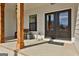 Close up of the front porch showing the wooden columns, double front door, and stylish decor at 135 Wet Wood Dr # 12, Fairburn, GA 30213