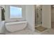 This luxurious bathroom features a modern soaking tub, marble floors, and a glass-enclosed shower at 135 Wet Wood Dr # 12, Fairburn, GA 30213