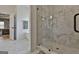 Modern bathroom featuring marble tiling, glass enclosed shower, and soaking tub adjacent to the main bedroom at 135 Wet Wood Dr # 12, Fairburn, GA 30213