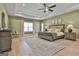 Spacious main bedroom with tray ceiling, light green walls, hardwood floors, and abundant natural light at 135 Wet Wood Dr # 12, Fairburn, GA 30213