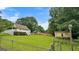 Beautiful backyard showcasing the home with a covered porch, mature trees, and a storage shed with a trailer at 3777 Edward Rd, Rex, GA 30273