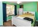 A bright bedroom featuring green walls, white furniture, including a bed, dresser, and blue curtains at 3777 Edward Rd, Rex, GA 30273