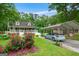 View of the home and carport from the yard, showcasing lush landscaping and beautiful red rose bushes at 3777 Edward Rd, Rex, GA 30273
