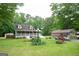 Two-story home with a big yard, complemented by a carport and decorative features at 3777 Edward Rd, Rex, GA 30273