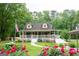 Inviting two-story home with covered porch, landscaped garden, and American flag at 3777 Edward Rd, Rex, GA 30273