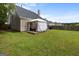 Backyard with a covered patio, seating area, grill, and well-maintained lawn at 1871 Sandy Trail Dr, Hampton, GA 30228
