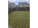 Spacious backyard enclosed with a wooden fence, with a grass lawn, and trees at 1871 Sandy Trail Dr, Hampton, GA 30228
