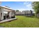 Spacious backyard with a covered patio, seating area, trampoline, and well-maintained lawn at 1871 Sandy Trail Dr, Hampton, GA 30228