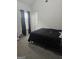 View of a bedroom with gray carpet and a black comforter on the bed at 1871 Sandy Trail Dr, Hampton, GA 30228
