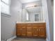 Bathroom vanity featuring wood cabinets, double sinks, and a large mirror at 133 Deerfield Ln, Carrollton, GA 30116