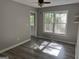 Cozy bedroom with wood-look floors, neutral walls, and bright natural light from the back deck at 133 Deerfield Ln, Carrollton, GA 30116