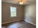 A bright bedroom with wood-look floors, neutral walls, with natural light coming through the window at 133 Deerfield Ln, Carrollton, GA 30116