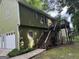 Back exterior view of a house with a wooden staircase leading to a deck and a convenient garage at 133 Deerfield Ln, Carrollton, GA 30116