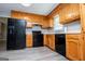Functional kitchen featuring wood cabinets and black appliances at 133 Deerfield Ln, Carrollton, GA 30116