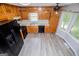 Corner kitchen with wood cabinets, black appliances, and gray wood-look floors at 133 Deerfield Ln, Carrollton, GA 30116