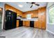 Traditional eat-in kitchen featuring wood cabinets, black appliances, and gray wood-look floors at 133 Deerfield Ln, Carrollton, GA 30116