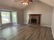 Spacious living room with a brick fireplace, vaulted ceiling, and large windows providing natural light at 133 Deerfield Ln, Carrollton, GA 30116