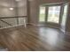 Bright living room featuring hardwood floors, a white staircase, and large windows at 133 Deerfield Ln, Carrollton, GA 30116