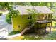 Back of home with a wooden deck and stairs in a wooded setting at 133 Deerfield Ln, Carrollton, GA 30116