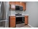 A kitchen area features a stainless steel refrigerator, microwave, and oven for modern convenience at 325 Berry Ct, Villa Rica, GA 30180