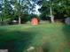View of the backyard and a small red barn in the corner at 5243 Eubanks Dr, Lake City, GA 30260