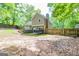 Green backyard surrounded by mature trees and a wooden fence, providing peace and privacy at 10 Queens Ct, Sharpsburg, GA 30277