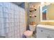 Charming bathroom featuring a tiled shower, white vanity, toilet, and decorative shelving at 10 Queens Ct, Sharpsburg, GA 30277