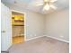 Carpeted bedroom featuring a view into the laundry room and a ceiling fan at 10 Queens Ct, Sharpsburg, GA 30277