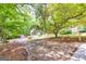 Circular driveway under a mature tree leading to a home with a storage shed at 10 Queens Ct, Sharpsburg, GA 30277