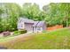 Charming two-story home surrounded by mature trees and lush landscaping on a sloped lot at 10 Queens Ct, Sharpsburg, GA 30277