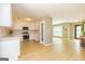 Open-concept kitchen features white cabinets, stainless steel appliances, and wood flooring, perfect for modern living at 10 Queens Ct, Sharpsburg, GA 30277