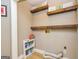 Functional laundry room with wooden shelves and a convenient storage cart for cleaning supplies at 10 Queens Ct, Sharpsburg, GA 30277