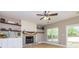 Cozy living room with stone fireplace, built-in shelving, ceiling fan, and natural light at 10 Queens Ct, Sharpsburg, GA 30277