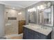 Modern bathroom featuring double sinks, a walk-in shower, and decorative mirrors at 230 Shorewood Ct, Mcdonough, GA 30252