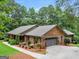 View of the home showing the attached garage, nice yard, and brick and cedar shake siding at 230 Shorewood Ct, Mcdonough, GA 30252
