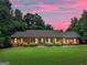 Charming brick home with a long porch and landscaped front yard under a beautiful pink sunset sky at 230 Shorewood Ct, Mcdonough, GA 30252