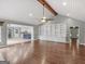 Open-concept living room with hardwood floors, built-in shelves, and views into the kitchen at 230 Shorewood Ct, Mcdonough, GA 30252