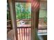 View from inside of a back deck with a table and chair and a wooded backdrop at 190 Princeton Way, Covington, GA 30016