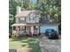 Charming two-story home featuring a welcoming front porch and attached garage, surrounded by lush trees at 190 Princeton Way, Covington, GA 30016