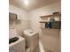 Well-lit laundry room with a washer, dryer, and shelving for storage at 190 Princeton Way, Covington, GA 30016