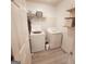 Bright laundry room with washer, dryer, wood-look flooring, and shelf storage at 190 Princeton Way, Covington, GA 30016
