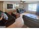 Living room with hardwood floors, dark leather furniture, and natural lighting at 190 Princeton Way, Covington, GA 30016