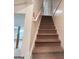 Carpeted stairs leading from the basement to the upper level of the house with a white handrail and a partly finished basement area at 190 Princeton Way, Covington, GA 30016
