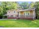 Beautiful two-story house featuring a cozy front porch, brick foundation, a covered carport, and a well-manicured green lawn at 115 Fairview Way, Stockbridge, GA 30281