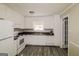 Functional kitchen featuring white appliances and cabinets, contrasted with dark countertops and modern vinyl flooring at 115 Fairview Way, Stockbridge, GA 30281